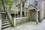 Backside of the home has tiered decking and a small seating area